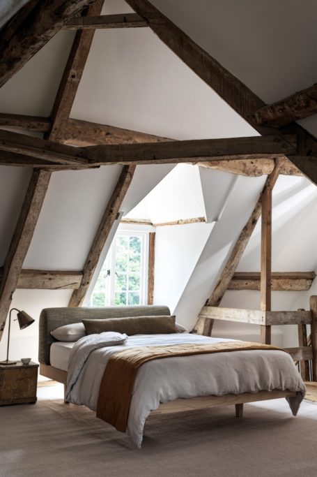 Bed in old house with wooden beam ceilings
