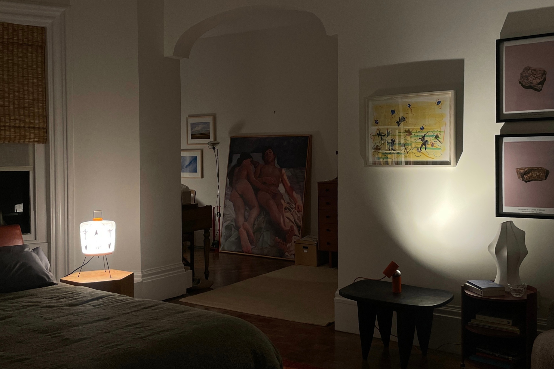 Bedroom with art on the walls and archway leading to home office