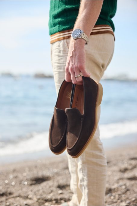 Man holding shoes in one hand