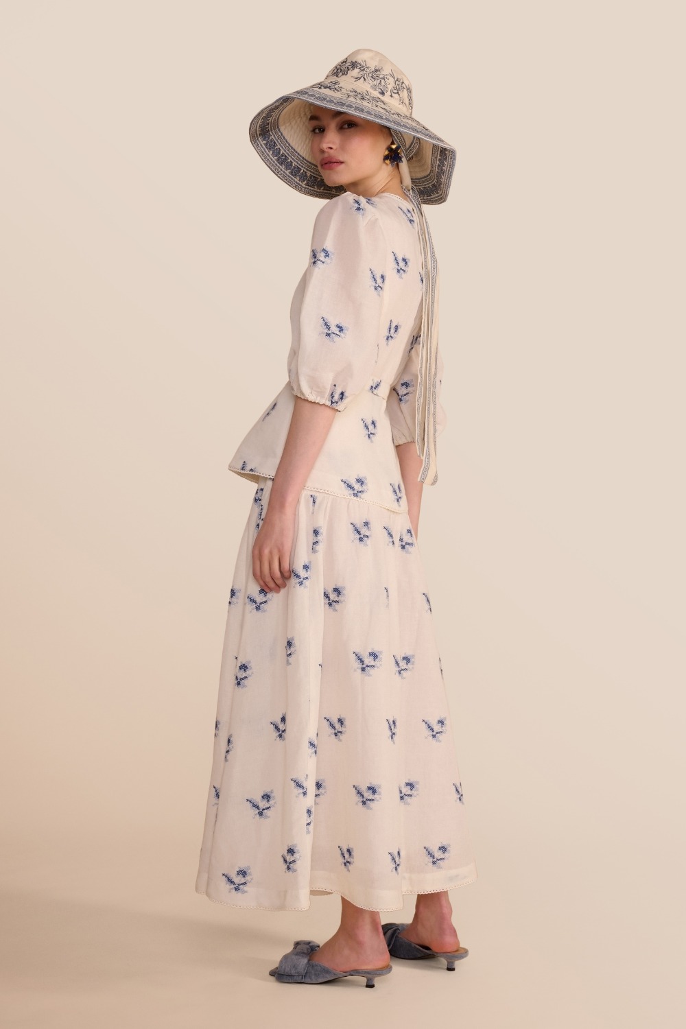 Woman in white and blue linen set with hat