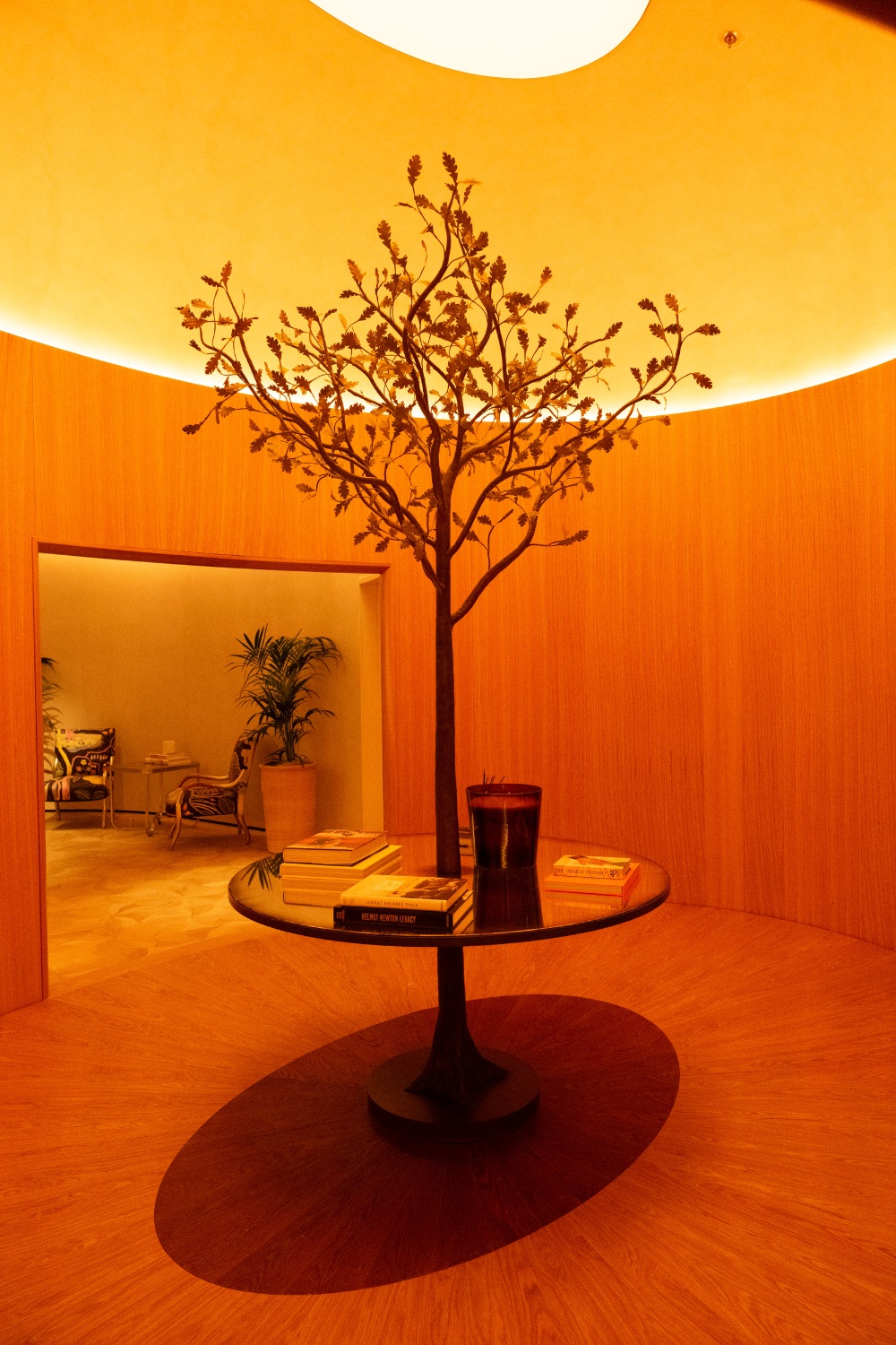 Gold-lit room with metal tree and table in the centre