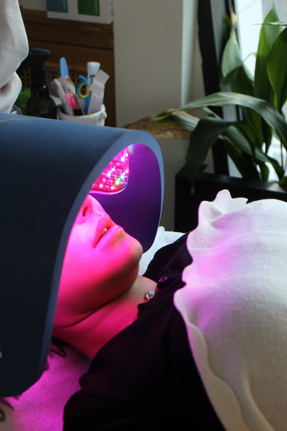 Woman lying down with a red light therapy mask on