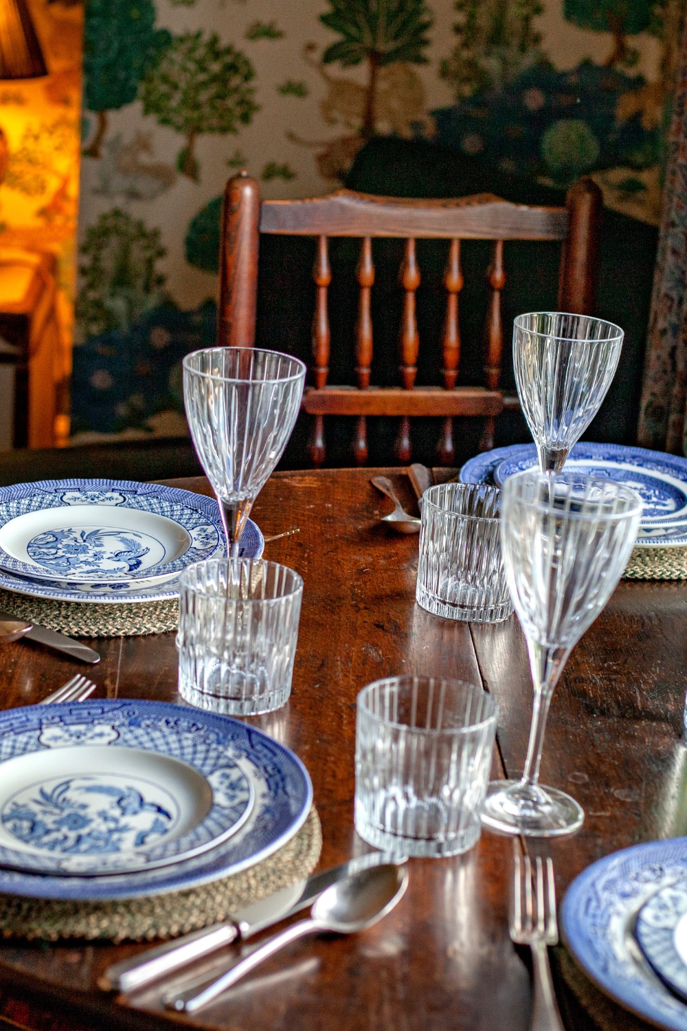 Wooden table set with blue Delft plates and glasses, design for 18th century gate lodge by Annie-Rose Chantler
