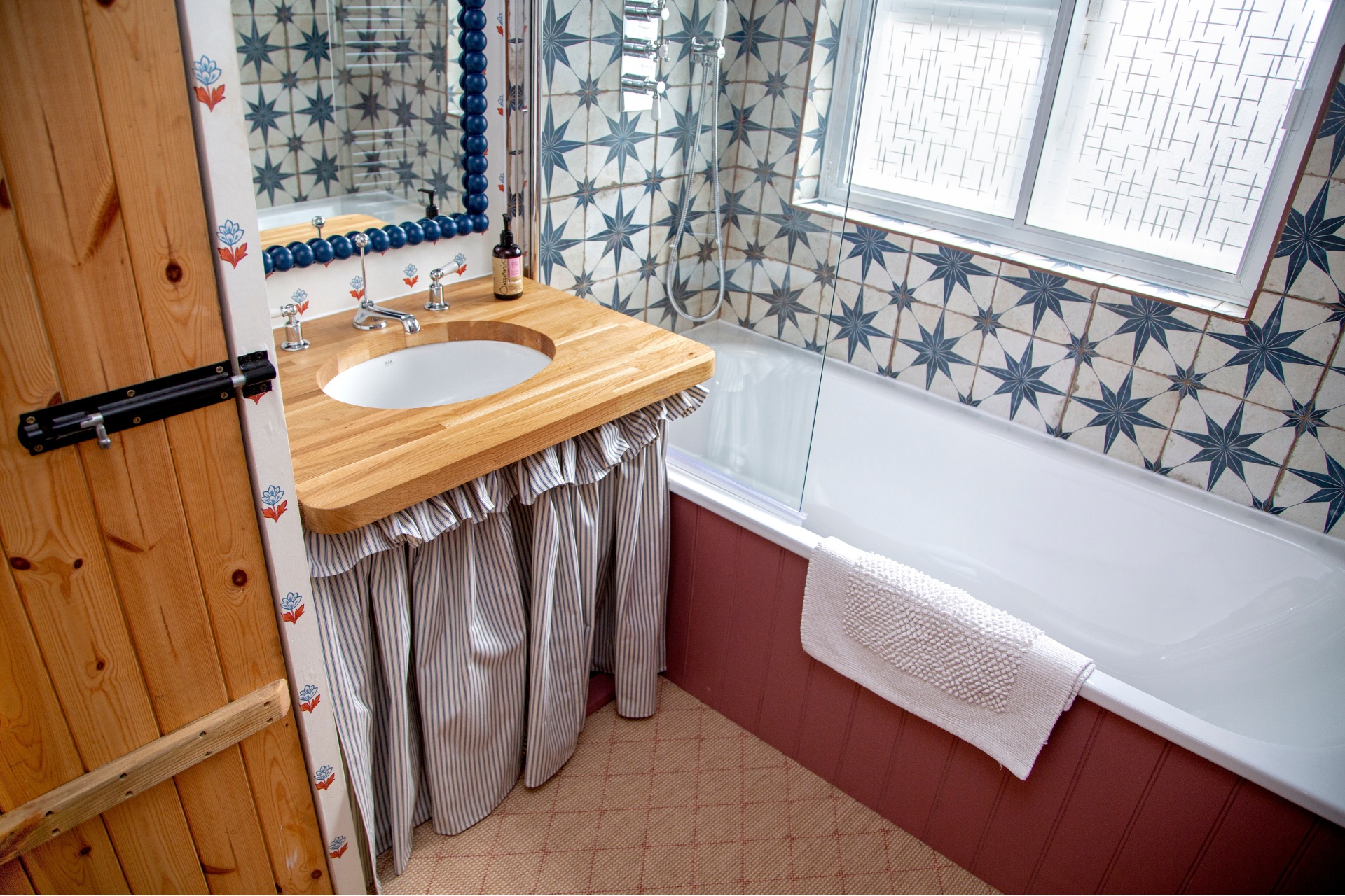 Bathroom with blue tiled walls and sink with skirt