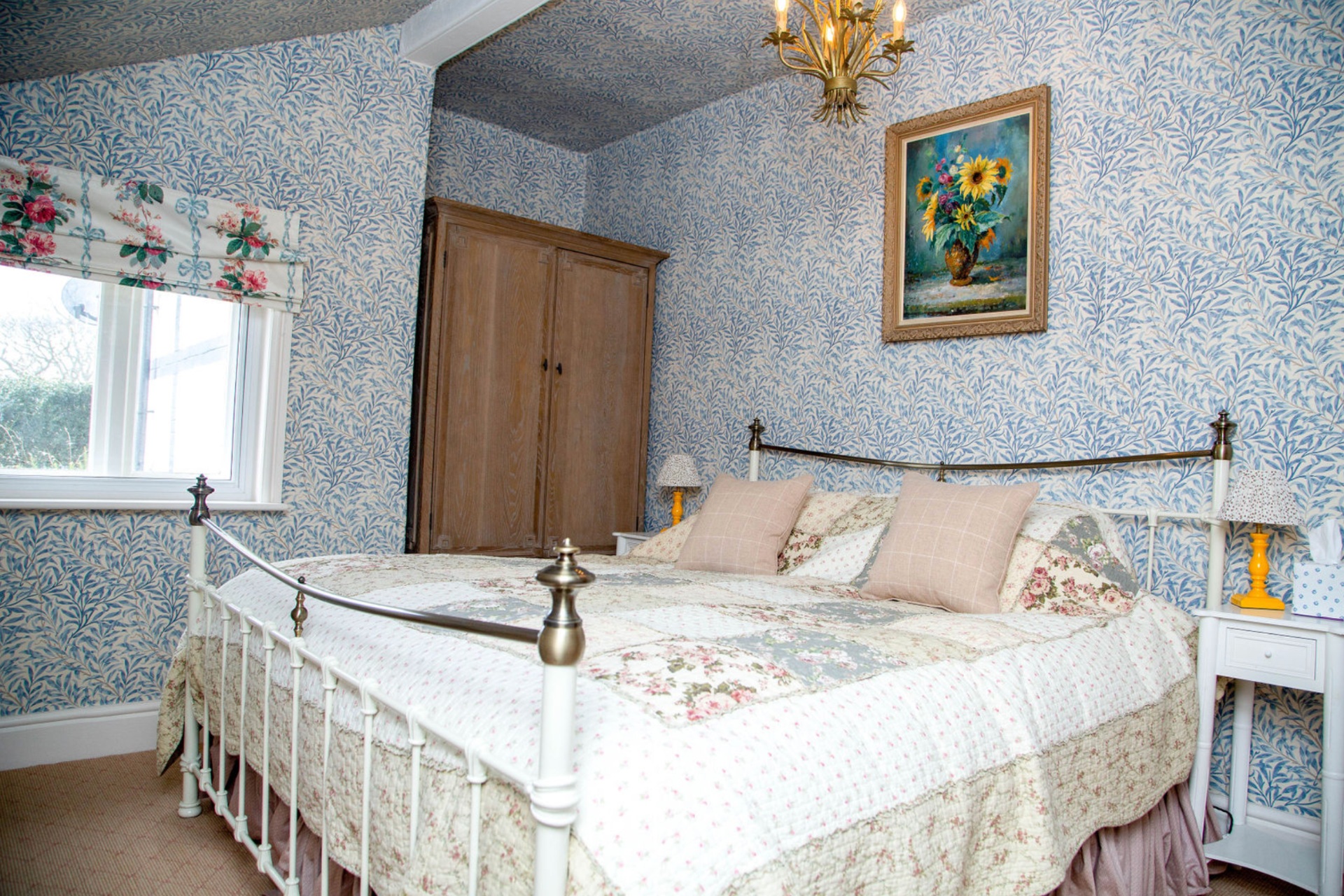 Bedroom with blue wallpaper and cream sheets