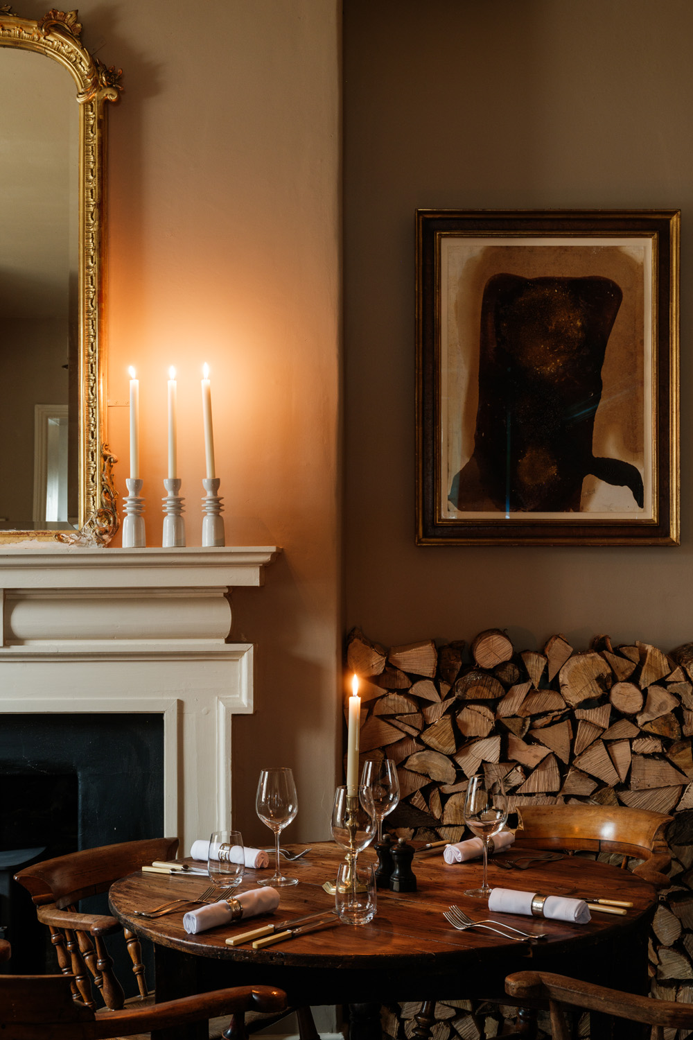 A set table beside a fireplace at The Bradley Hare