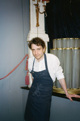 Chef Jackson Boxer leans against a wall