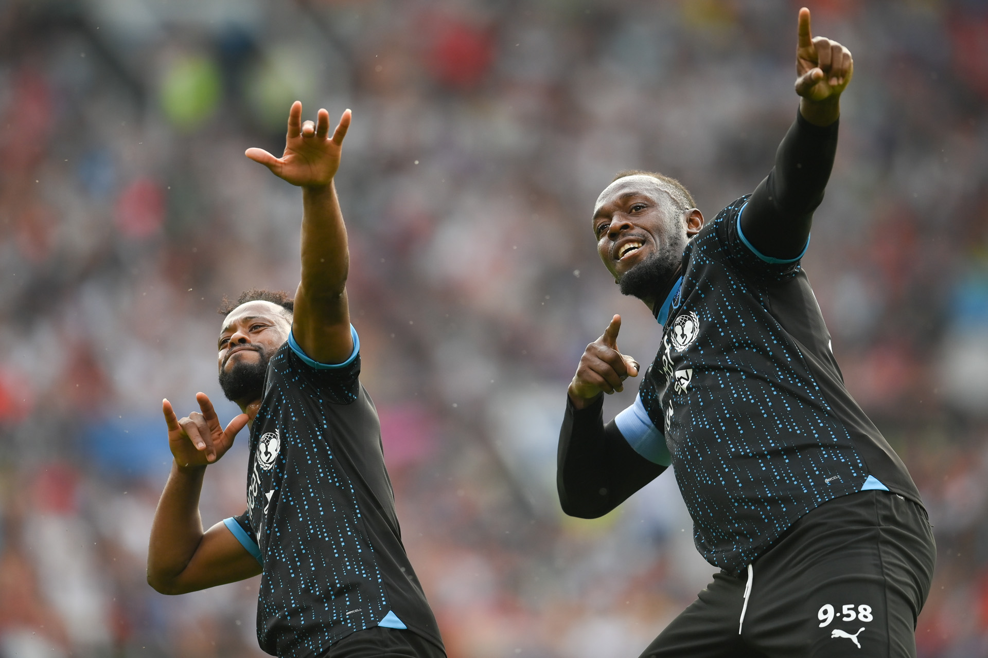Usain Bolt of World XI (right) celebrates with Patrice Evra of World XI after scoring his sides first goal during Soccer Aid for UNICEF 2023 taking place on Sunday 12th June at the Old Trafford, Manchester