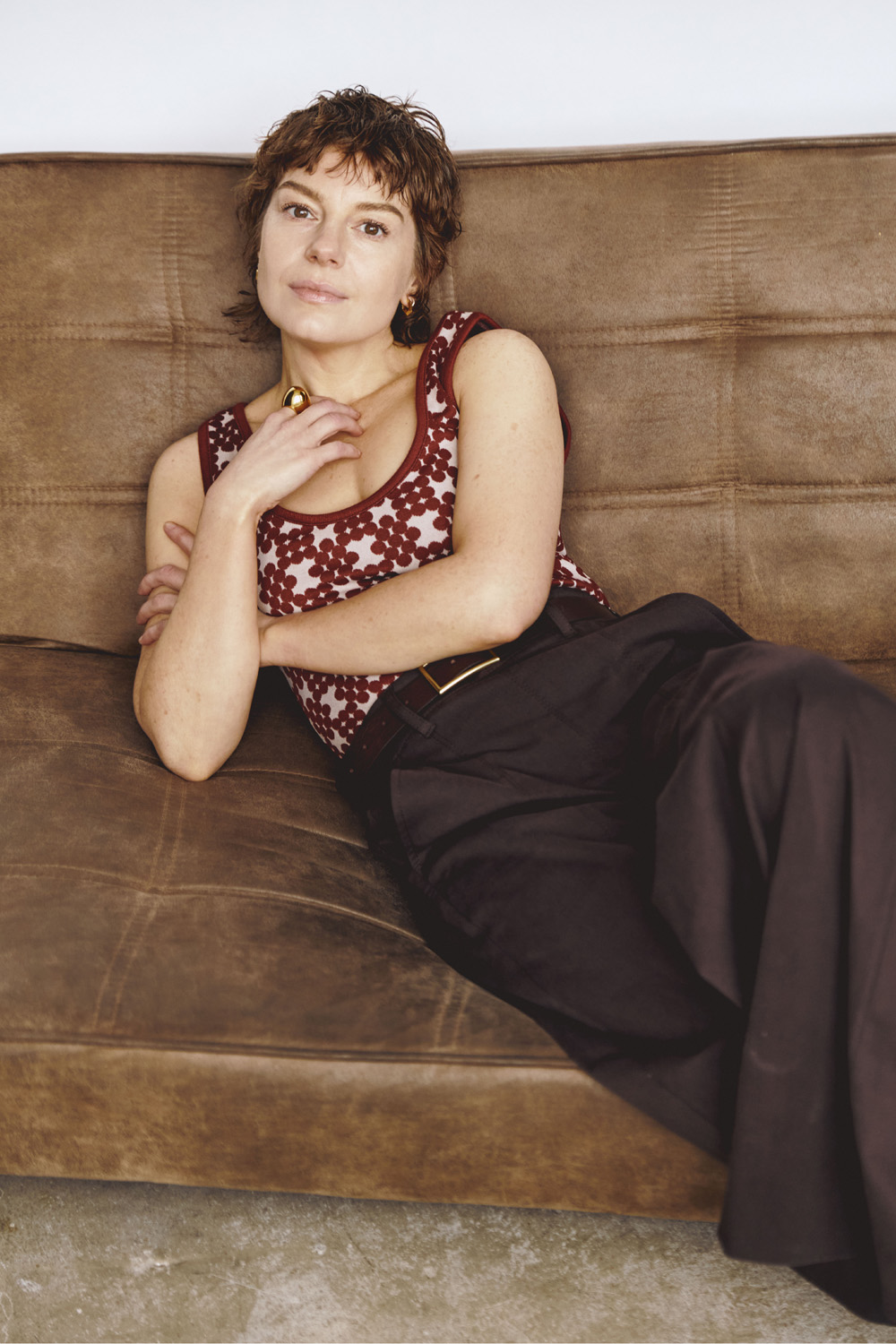 Aimée-Ffion Edwards lounging on a brown leather sofa