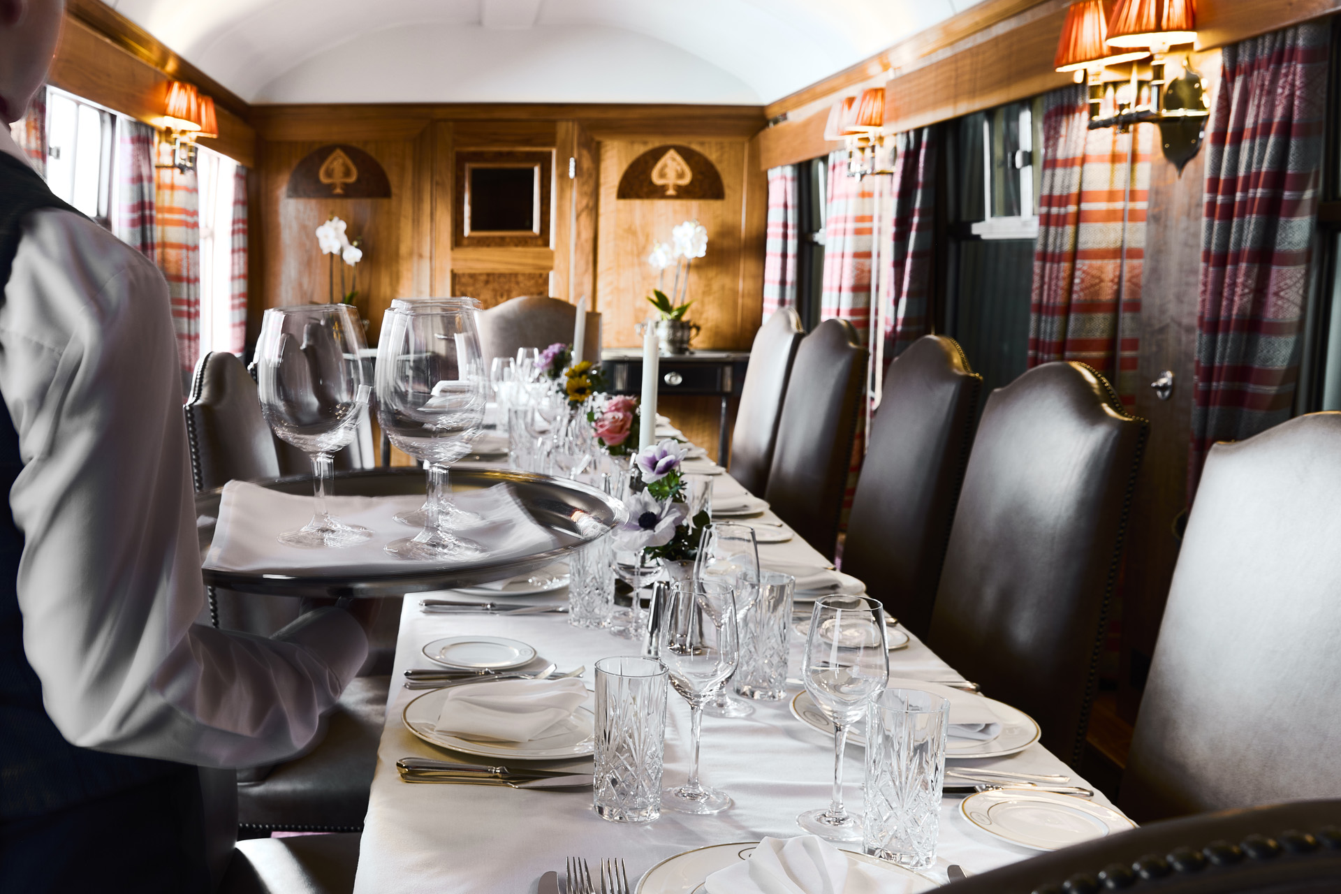 A steward serving dinner on The Chairman’s Train