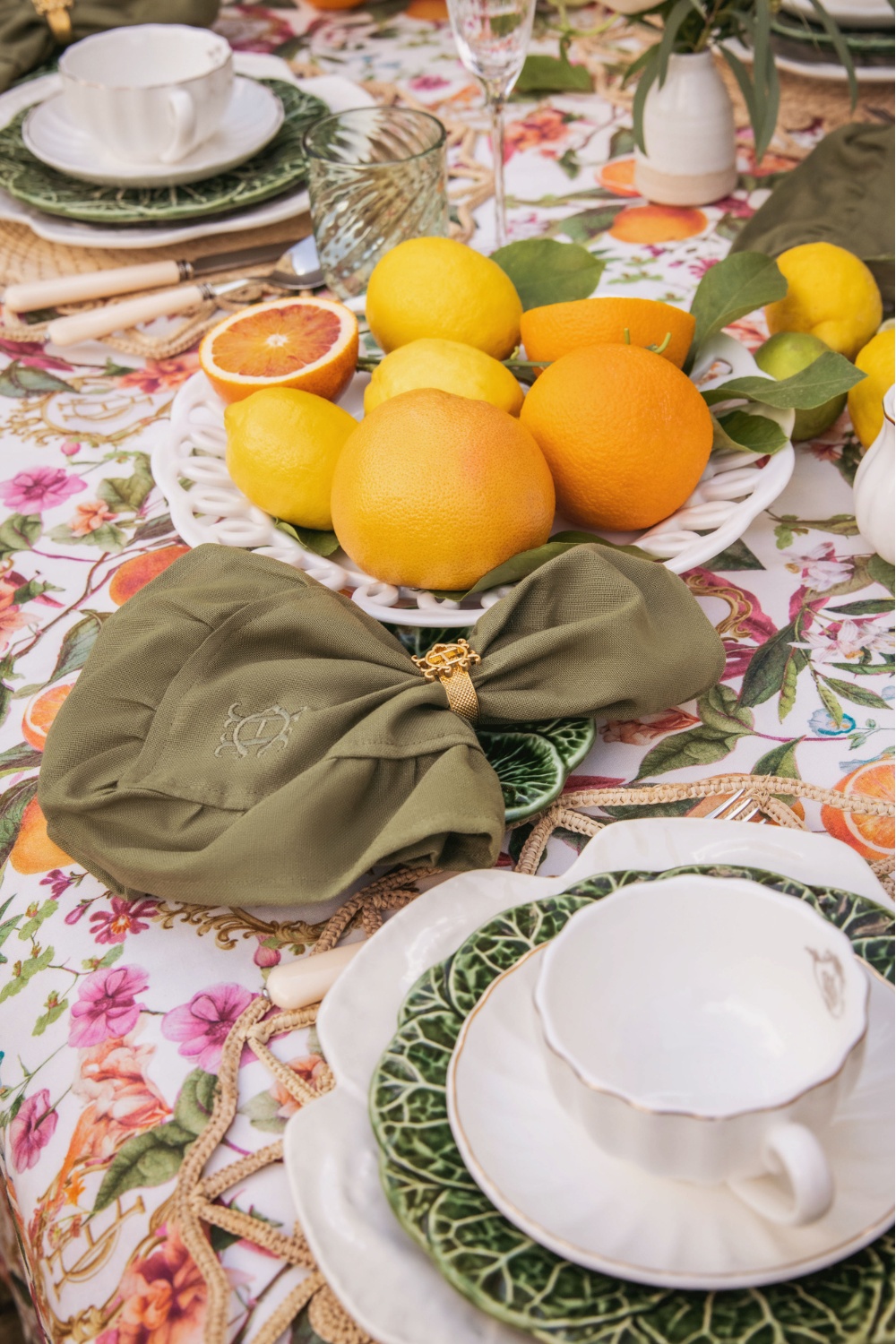 Close up of table with floral linens and plates of oranges