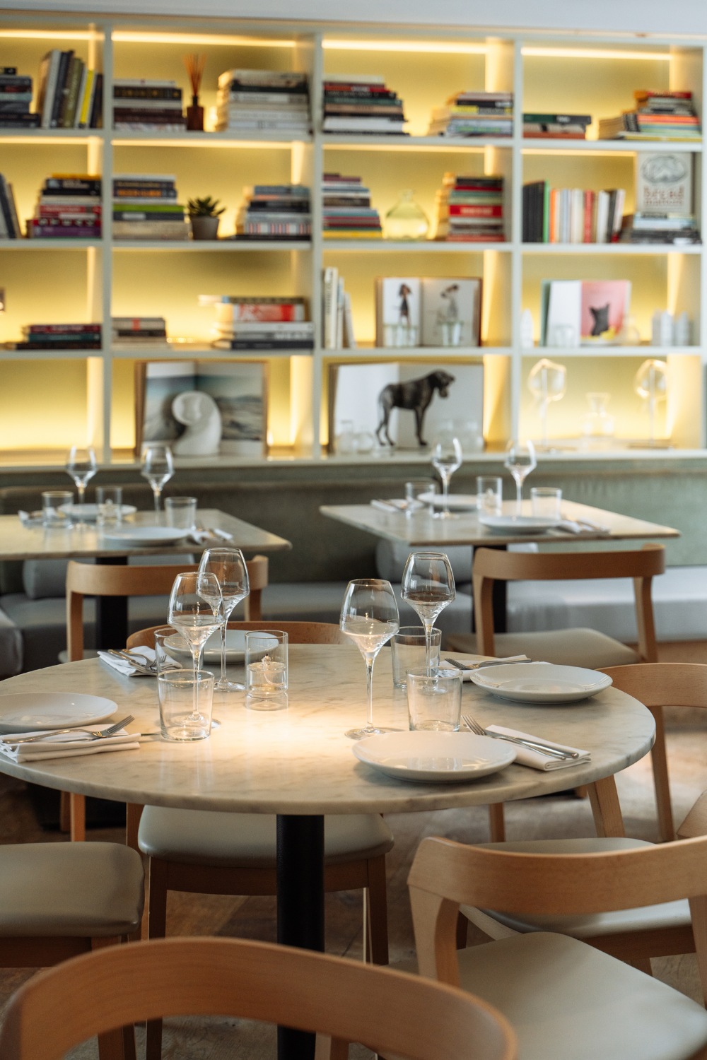 Dining tables with bookcase in the background, dining space at Lurra