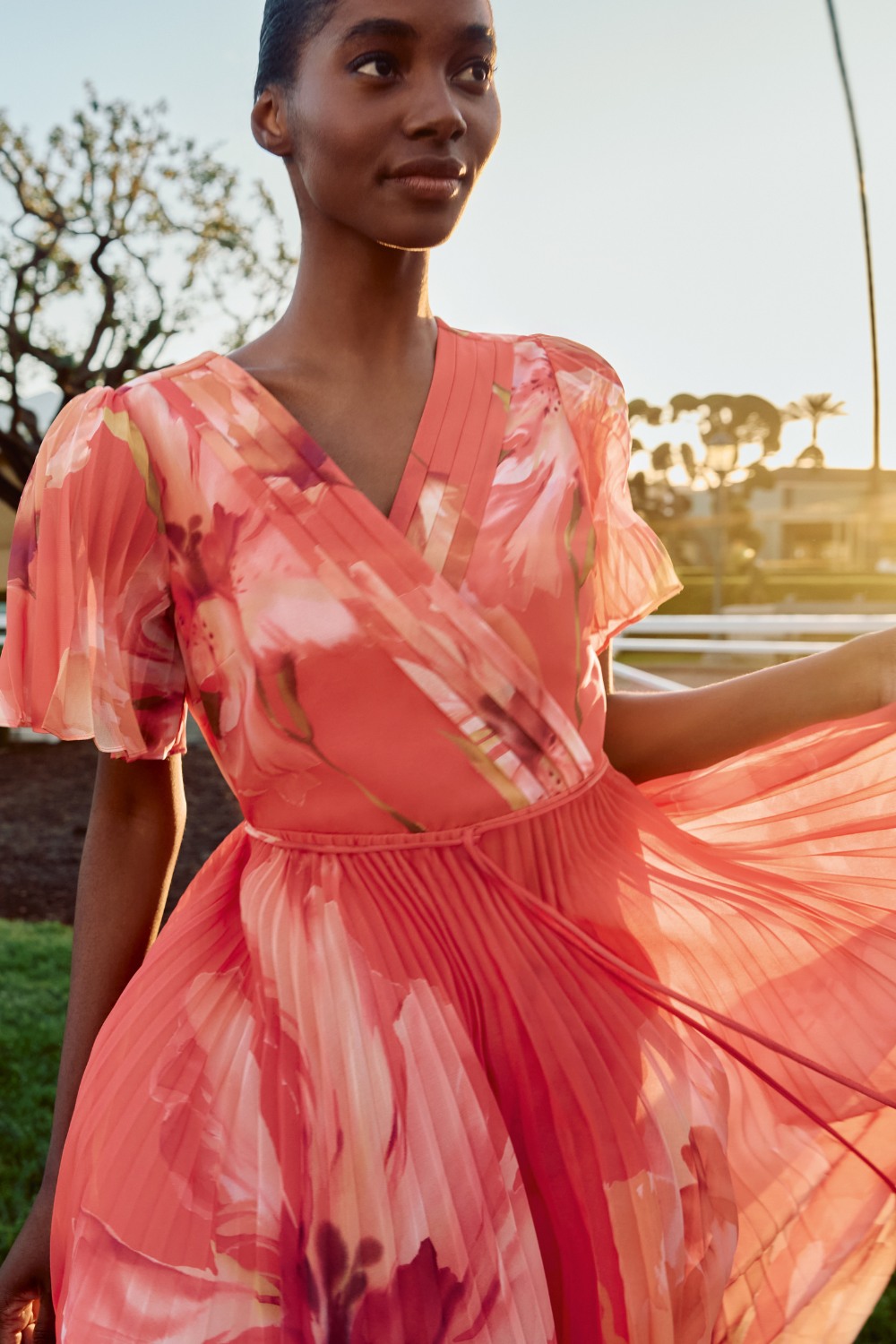 Woman wearing pink floral dress from Phase Eight summer occasionwear edit