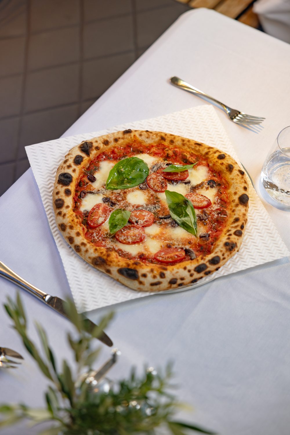 A margarita pizza on a white table