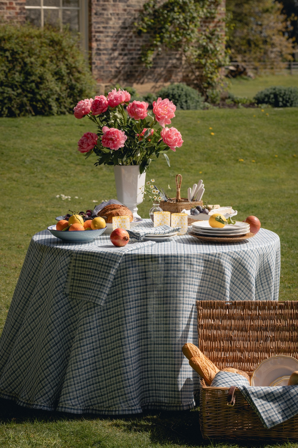 Table set outside with plates and vases of pink flowers | tableware by Rebecca Udall