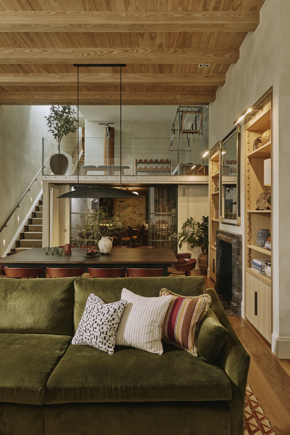 Basement with green sofa and mezzanine with gym