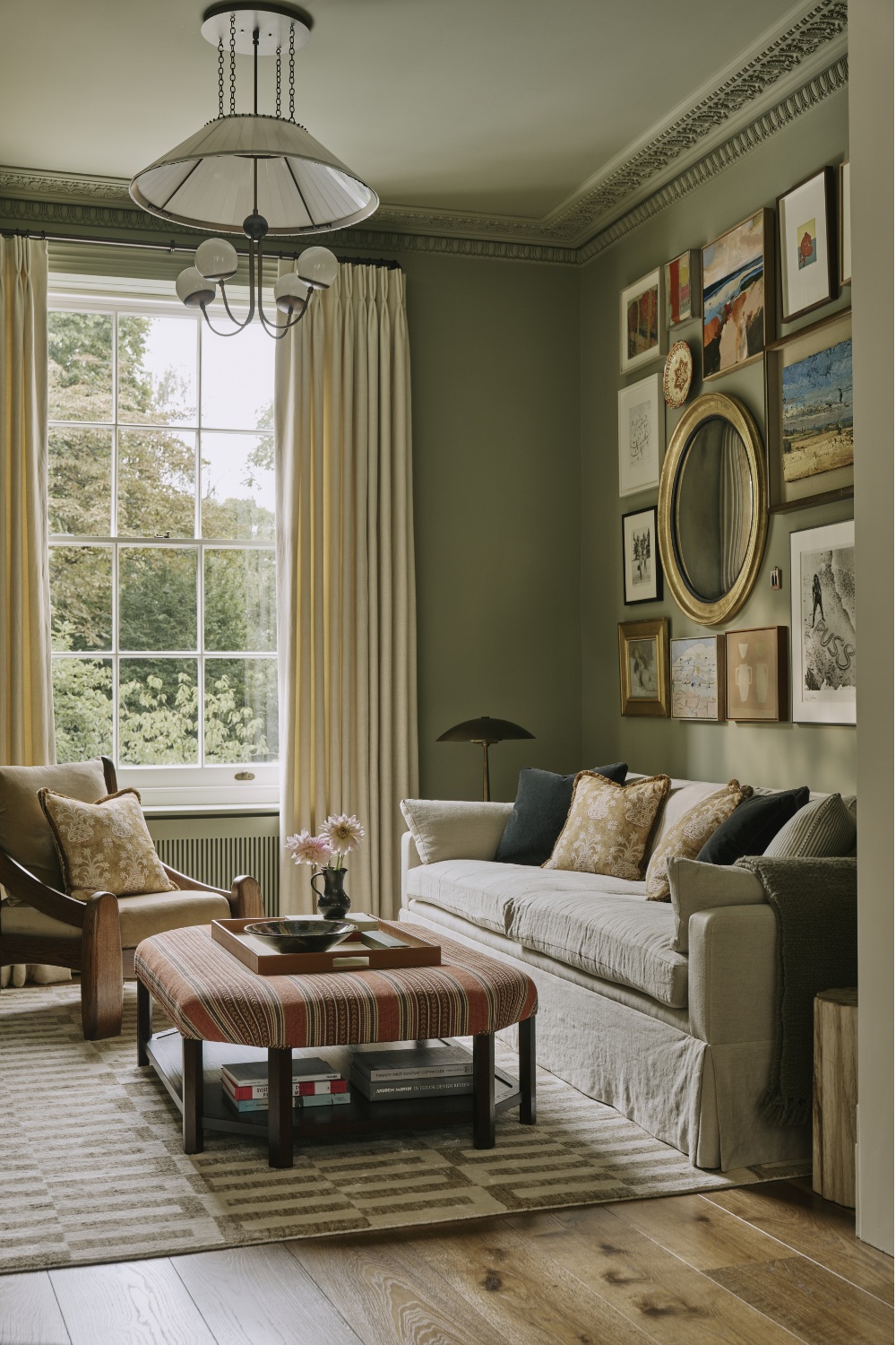 Snug room with green walls and gallery wall