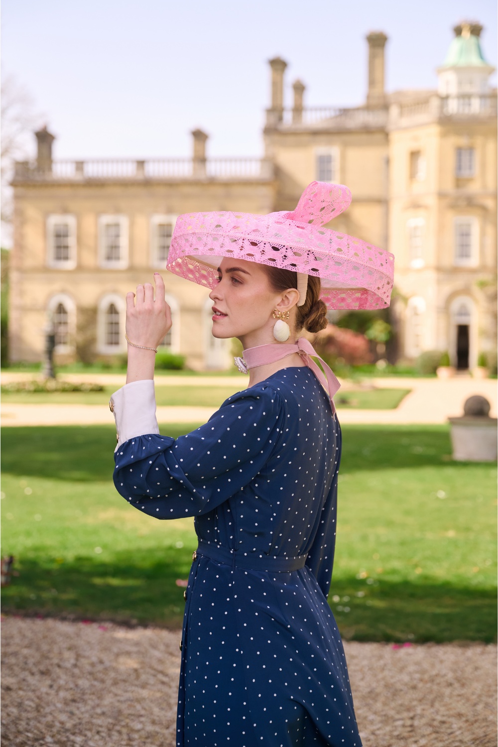 Woman wearing pink hat and navy dress from VV Rouleaux