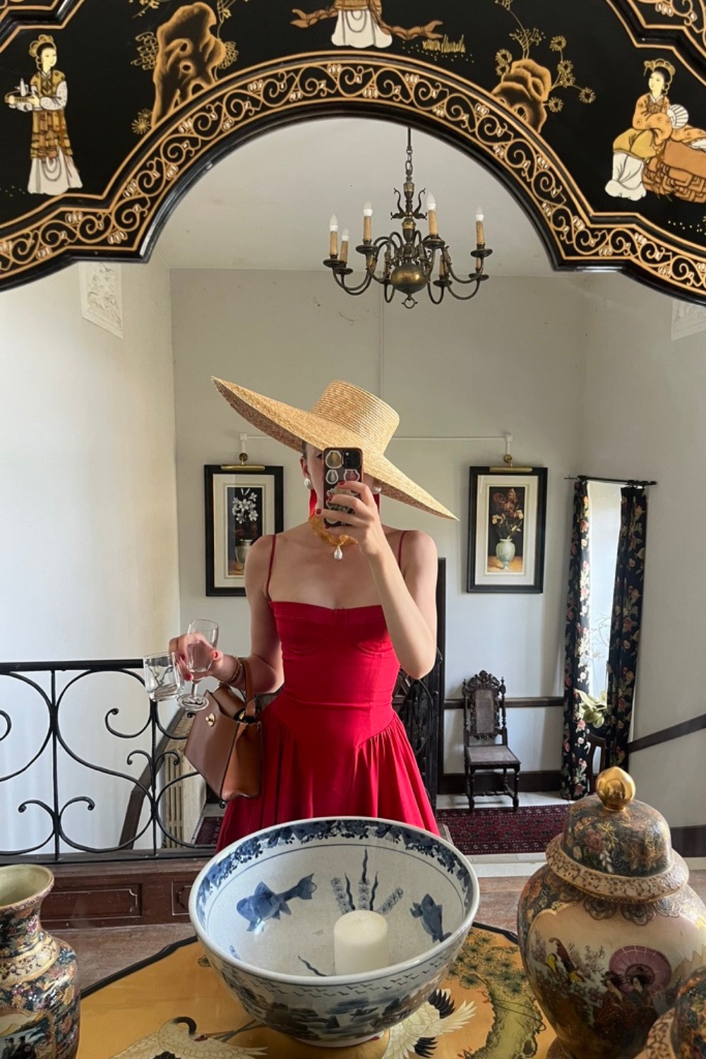 Stylist Alice Hare attending a summer wedding, her guest outfit includes a red dress and wide brimmed hat