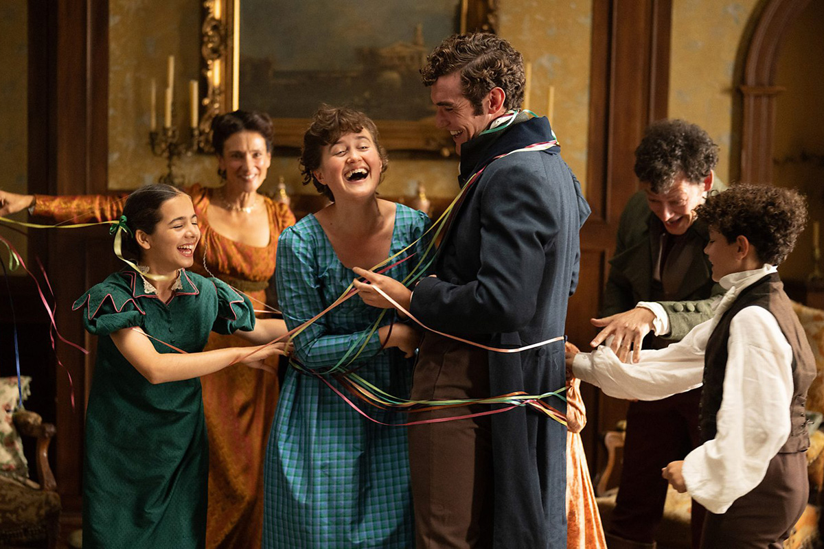 A promotional still from The Other Bennet Sister Christmas special featuring a family wrapping a couple in festive ribbons