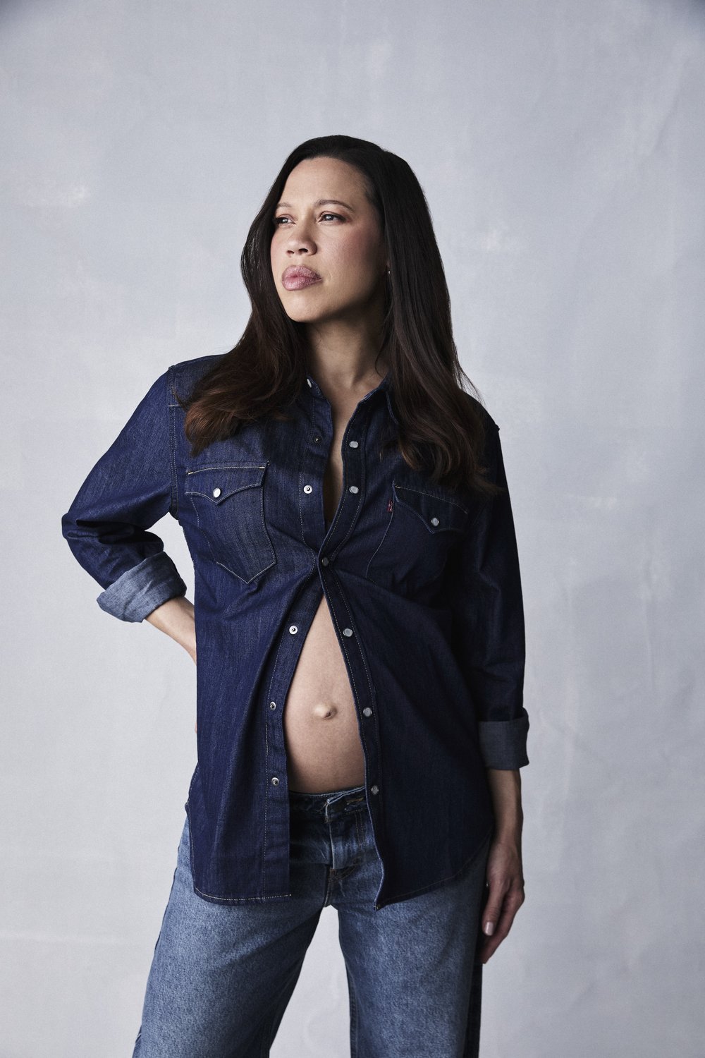 Remmie in double denim, standing with her hand on her hip, looking to the left