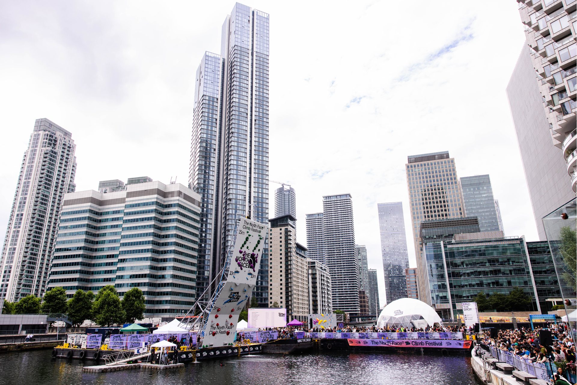 A North Face climbing wall surrounded by skyscrapers in Canary Wharf