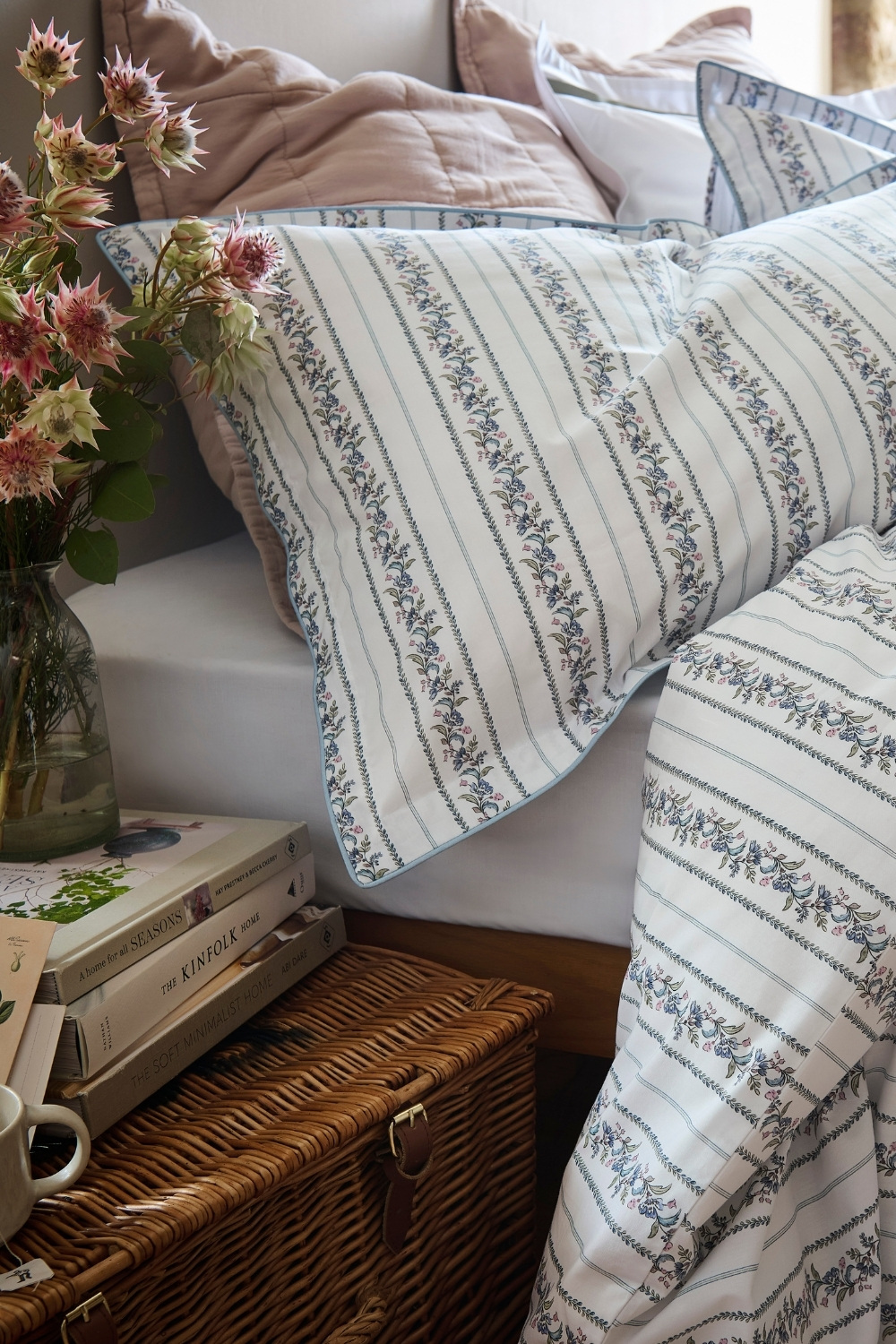 Close up of partially made bed with bedding by Christy