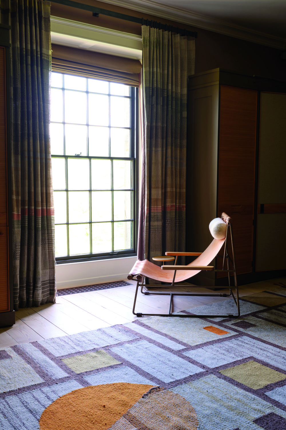 An empty chair facing a bright window