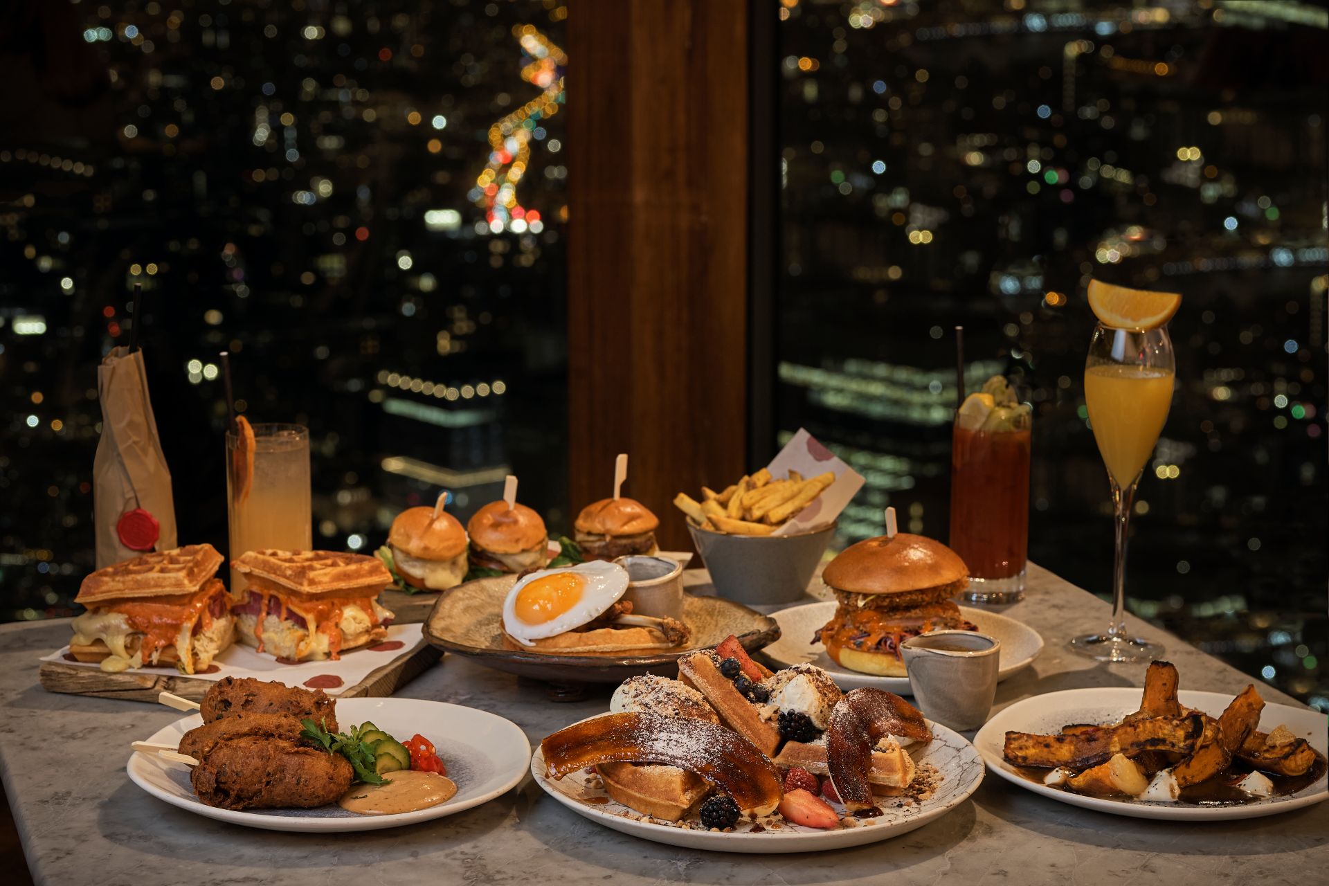 Plates of food with windows overlooking the London skyline behind