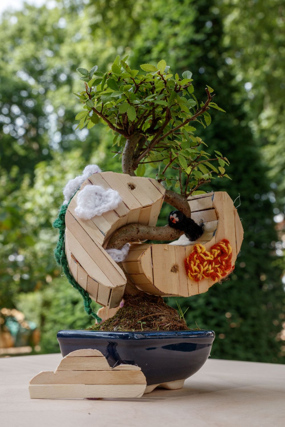 A Bonsai tree adorned with a koi themed treehouse
