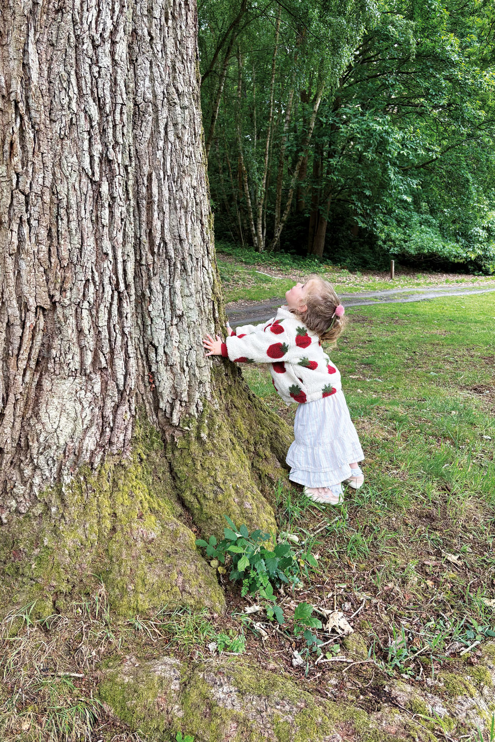 A child standing beside a tree