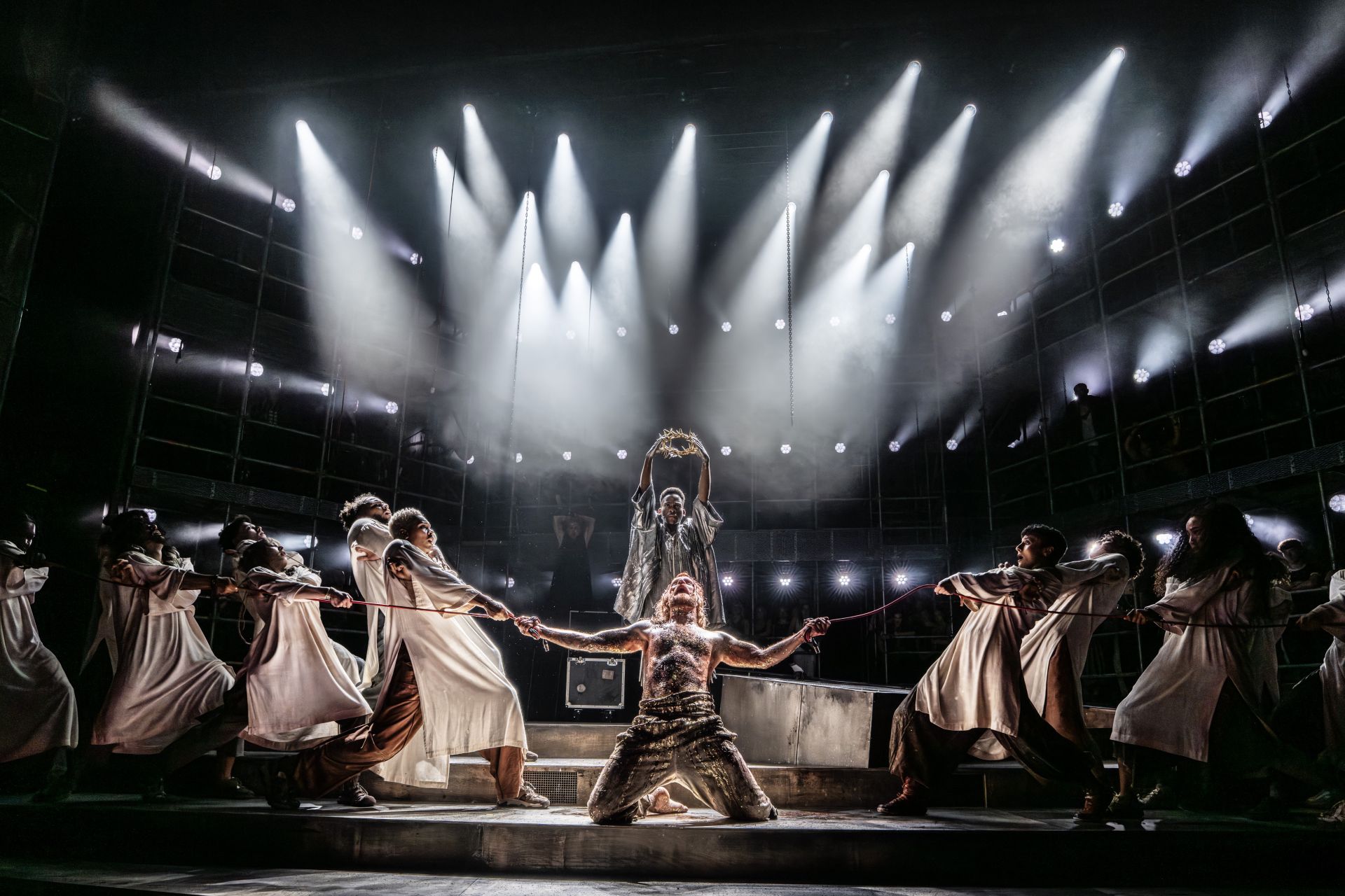 A dramatic image of Sam Rider as Jesus being pulled in two directions with Tyrone Huntley as Judas looming over