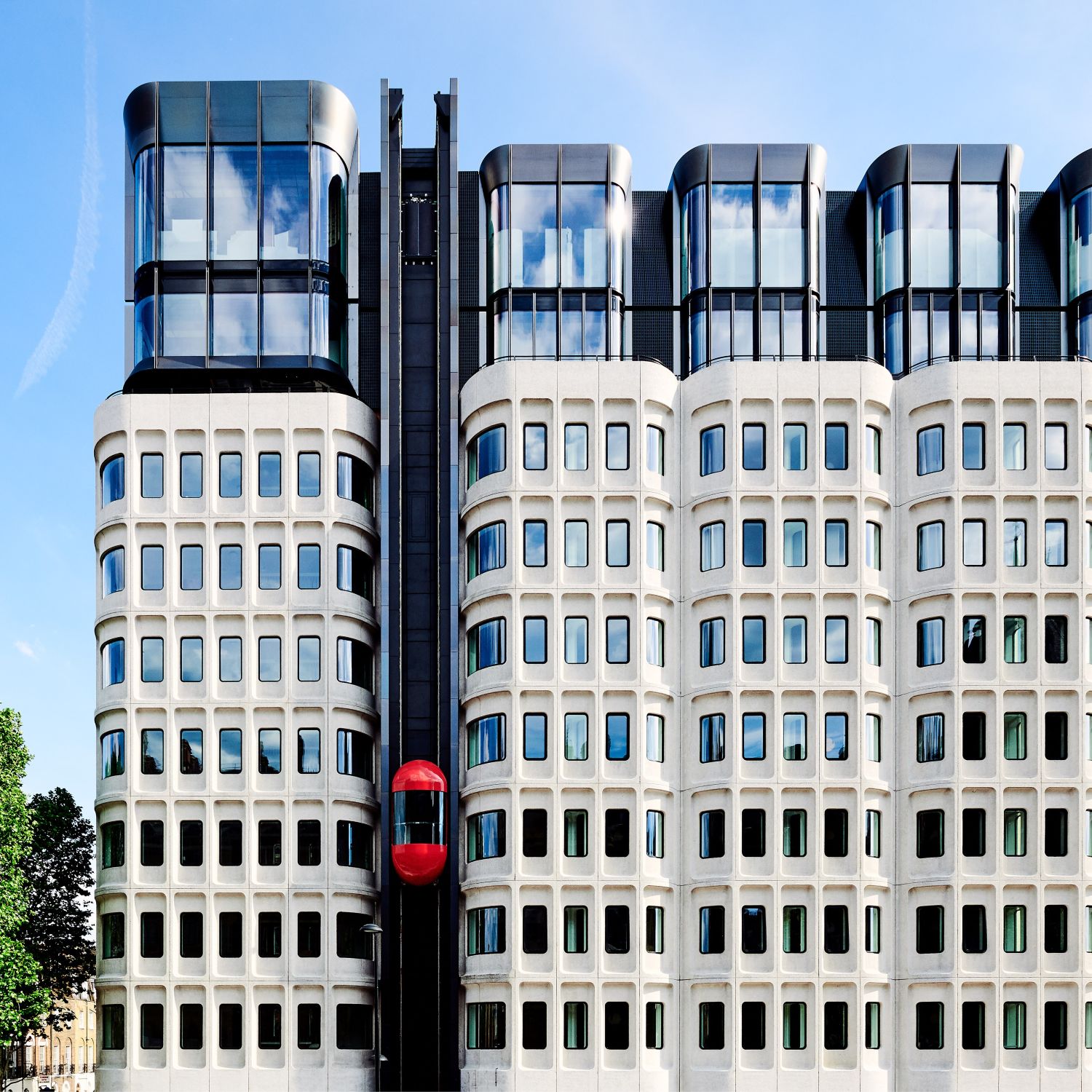 The red elevator rising to the top of The Standard London's exterior
