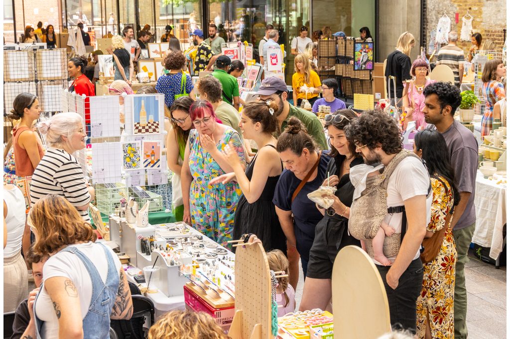A crowd of people perusing gifts at The Crafty Fox Market in King's Cross London