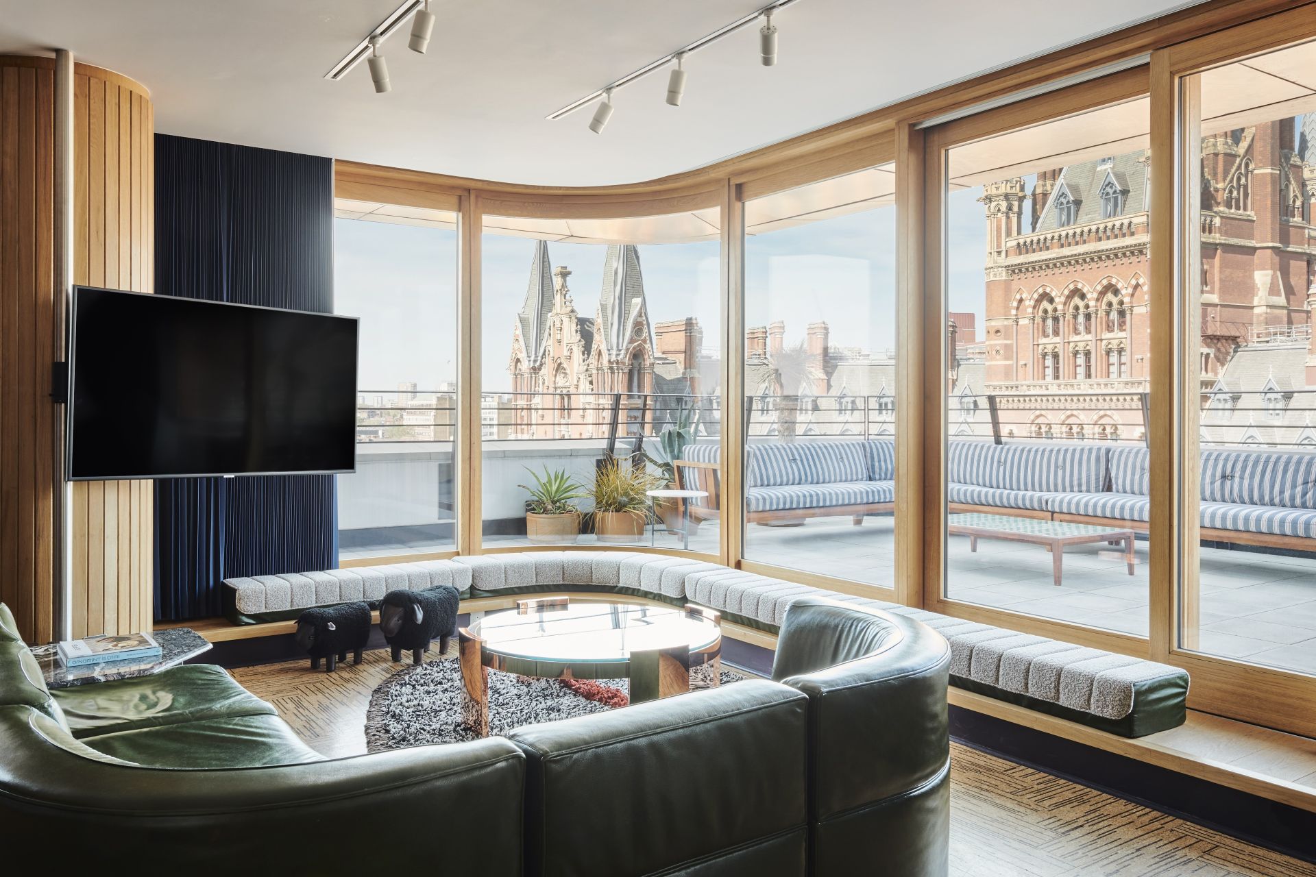 A large corner sofa facing floor to ceiling windows with a view of London St Pancras train station