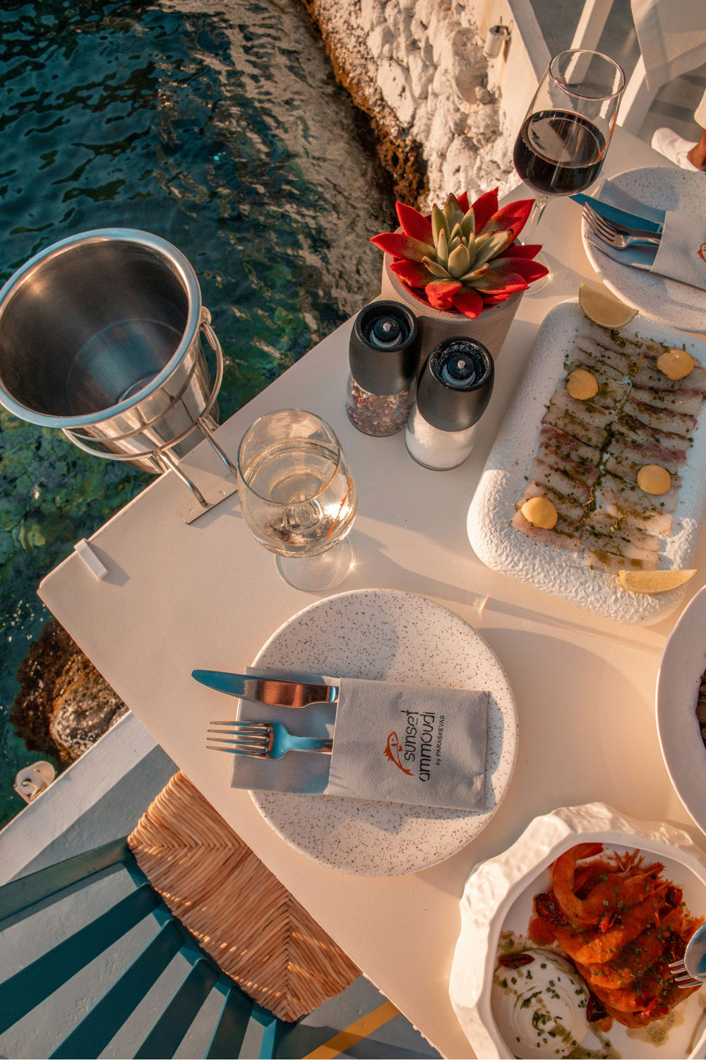 Red wine and food being served by the sea