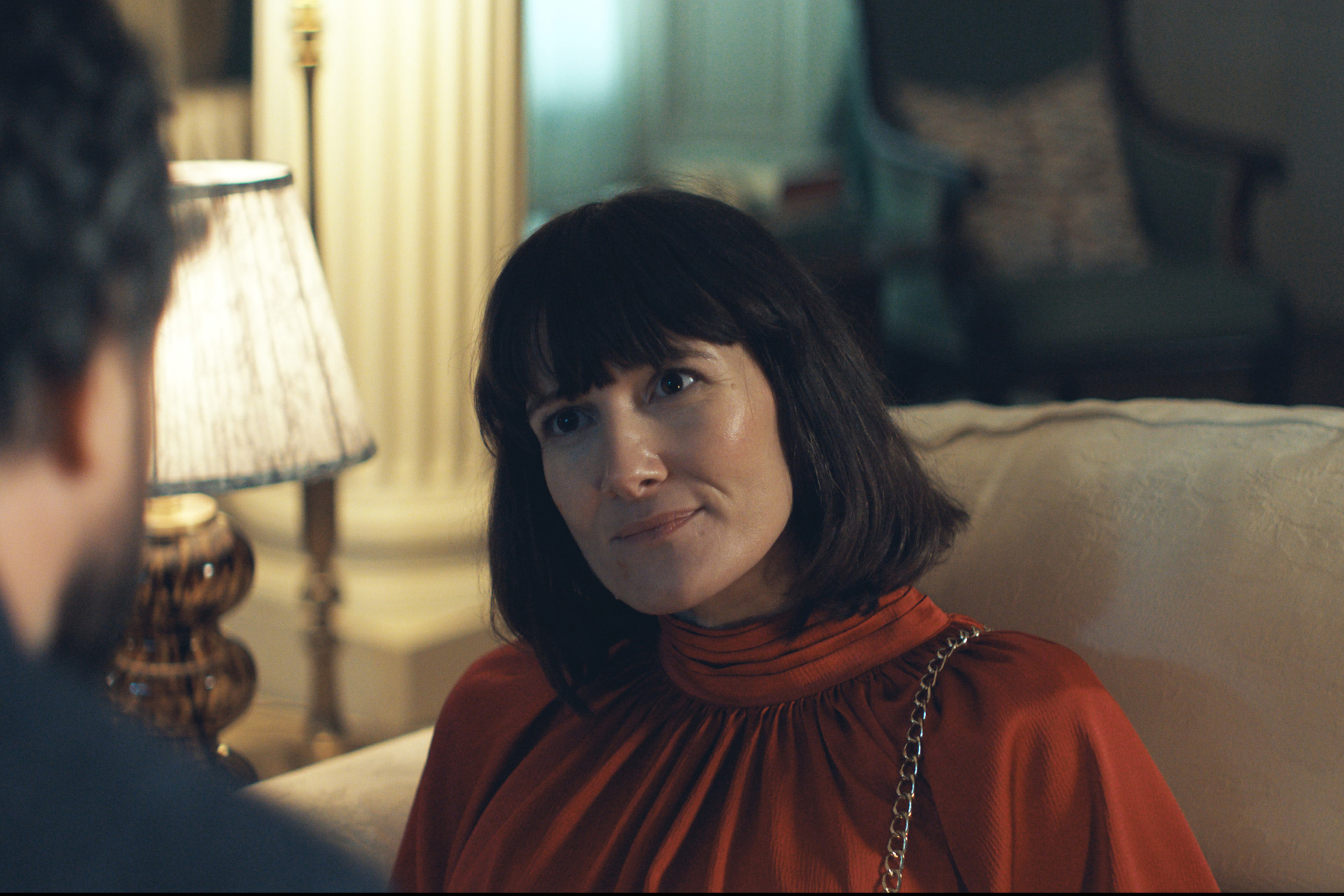 A still from The Party featuring Sarah Solemani with a blunt bob and a red blouse