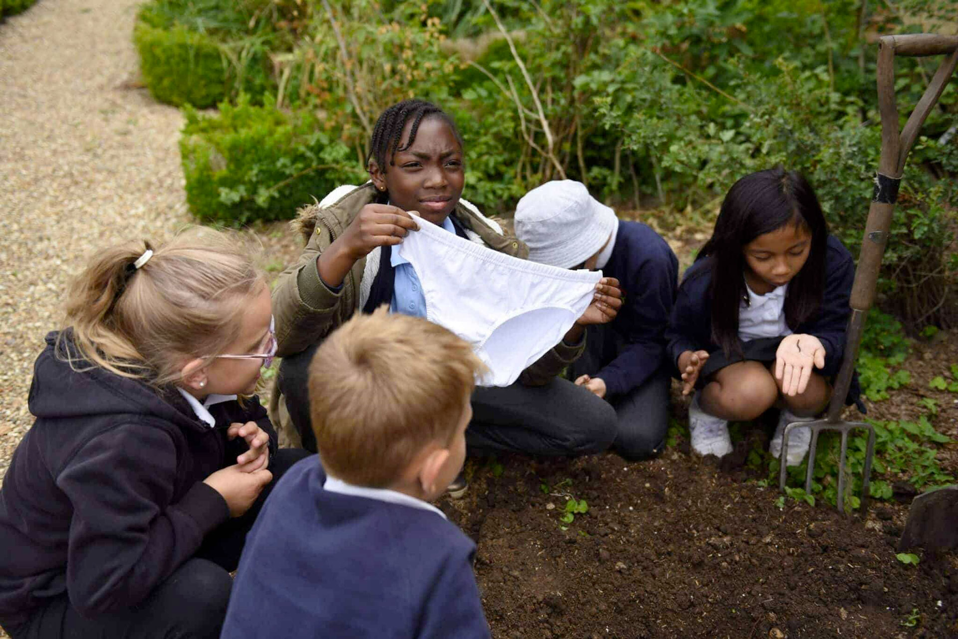 A child plants cotton clothing in order to demonstrate something about the environment and soil