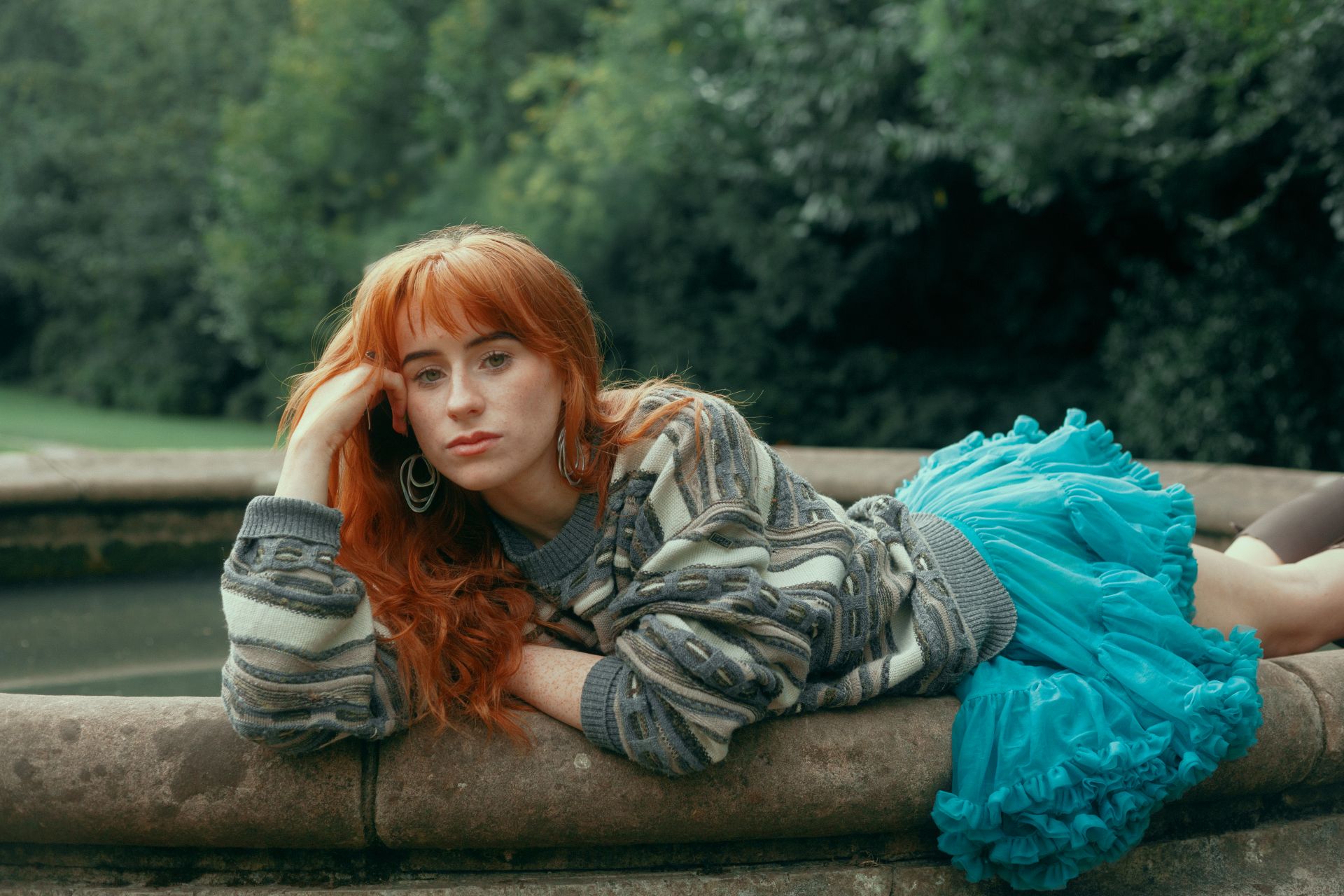 Aisling Sharkey resting on her arm on the side of a brick fountain