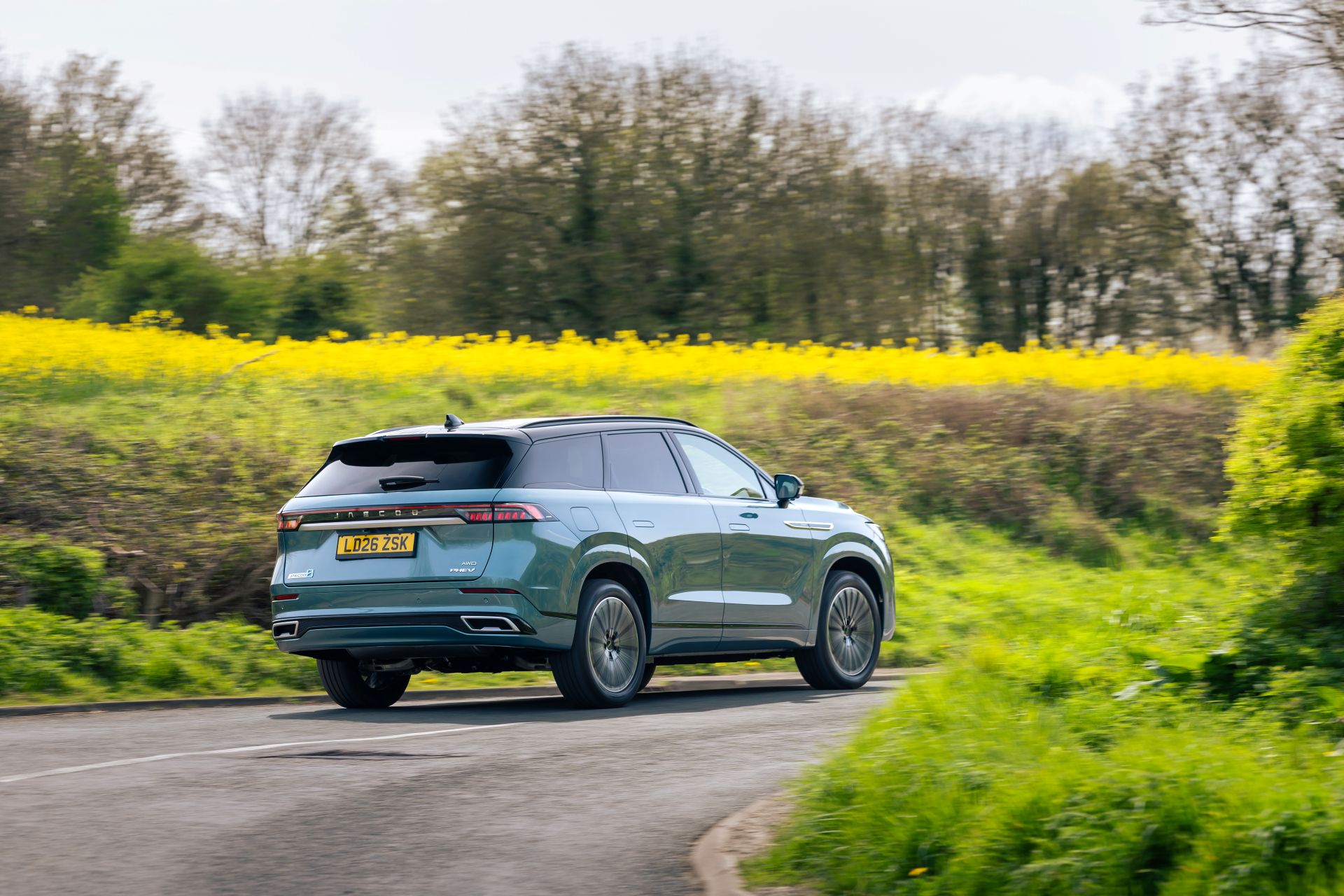 The Jaecoo 8 driving away on a country road