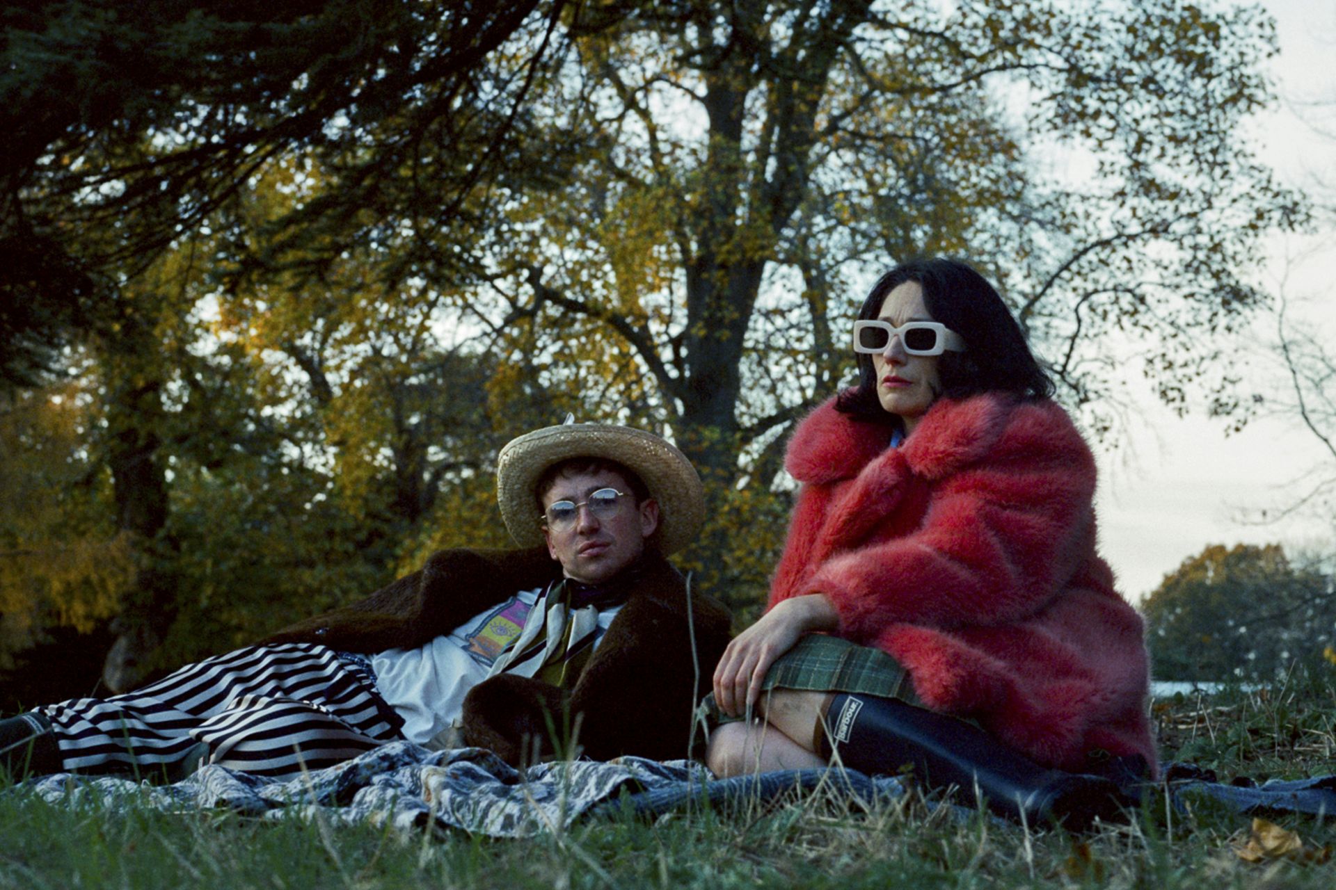 Laurie Kynastan and Sian Clifford in character in LADY, lounging on the ground outside