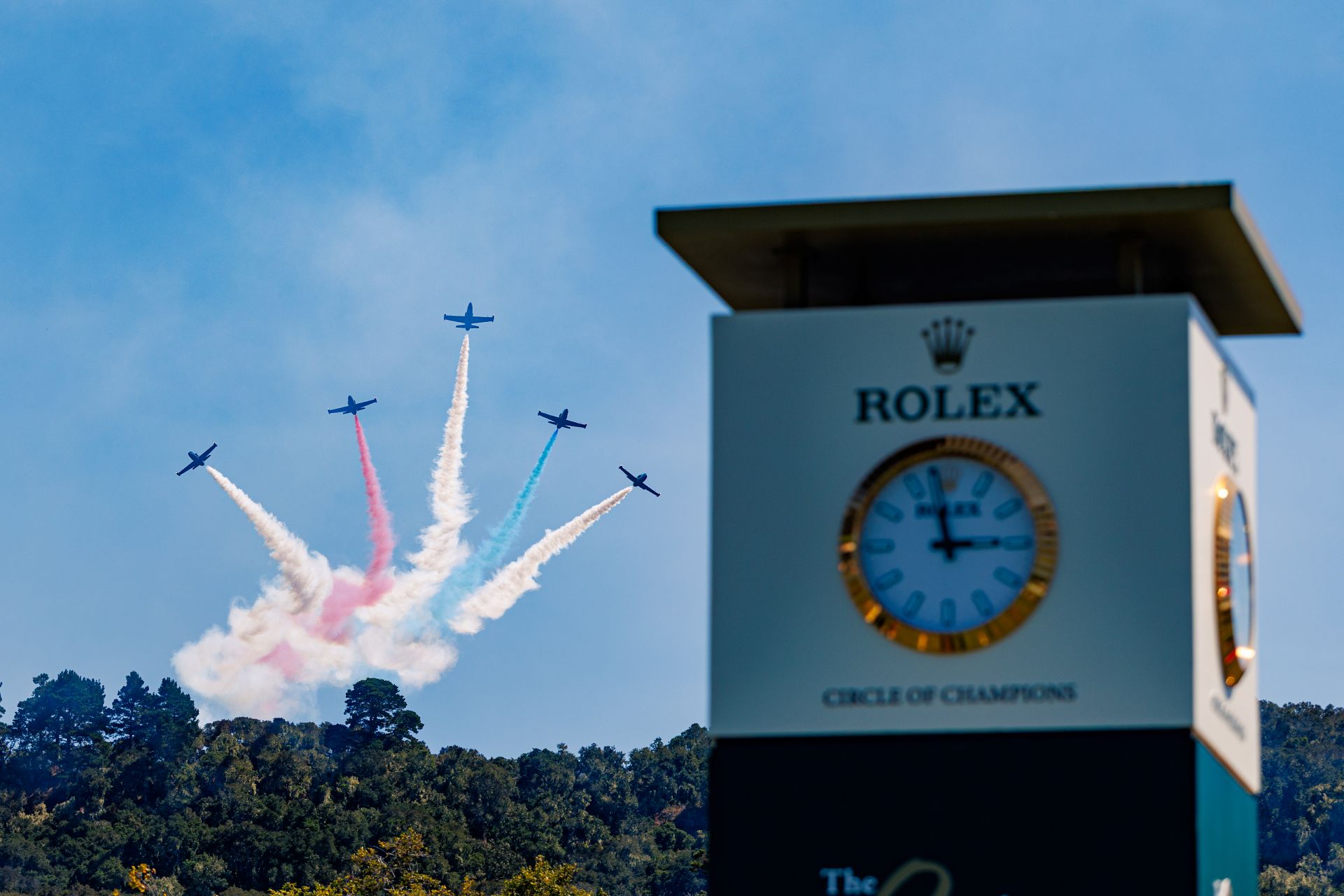 Jets flying into the sky beside a large ROlex clocktower