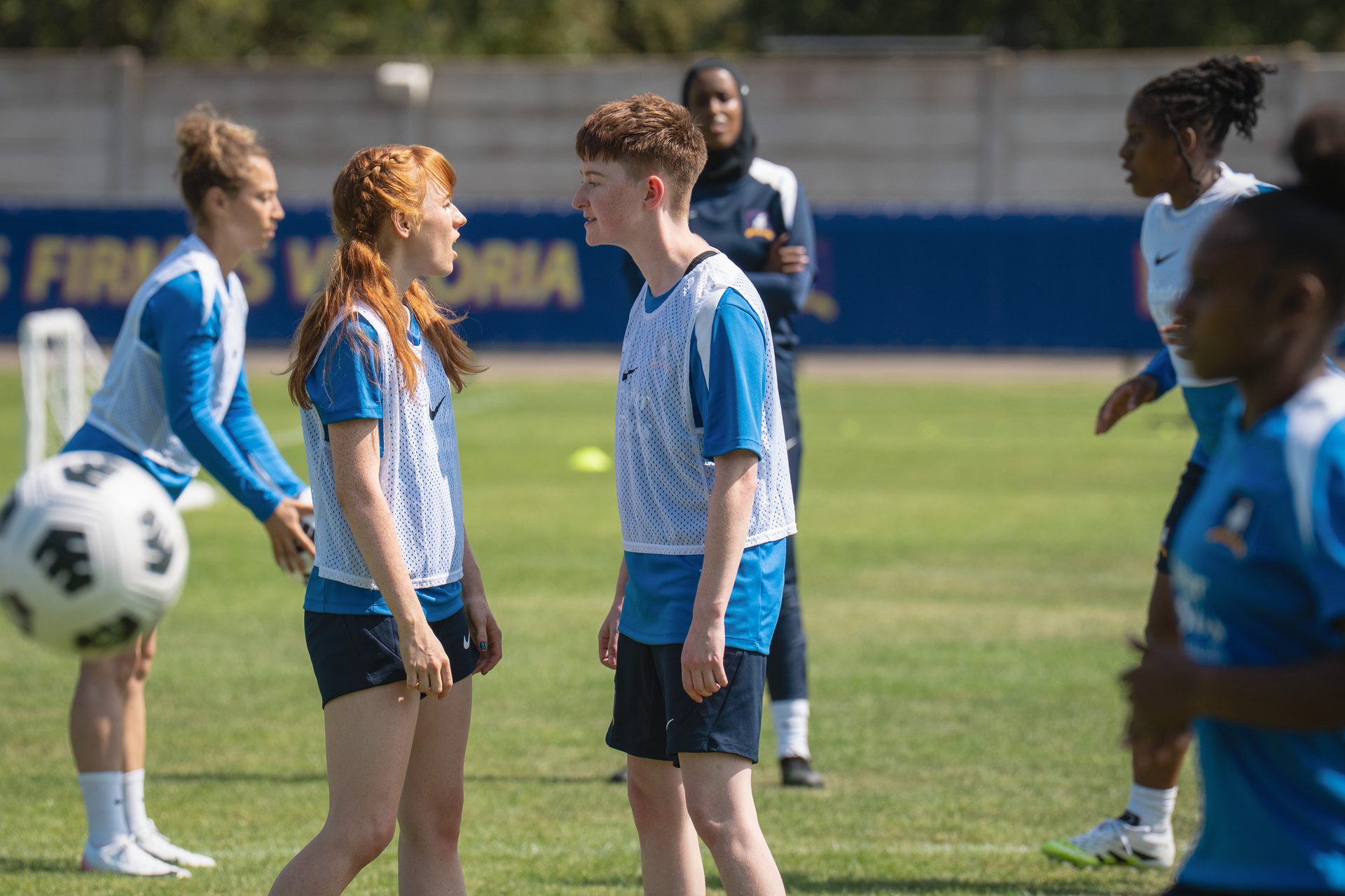 Aisling Sharkey and Rex Hayes wearing football kit on the set of Ted Lasso